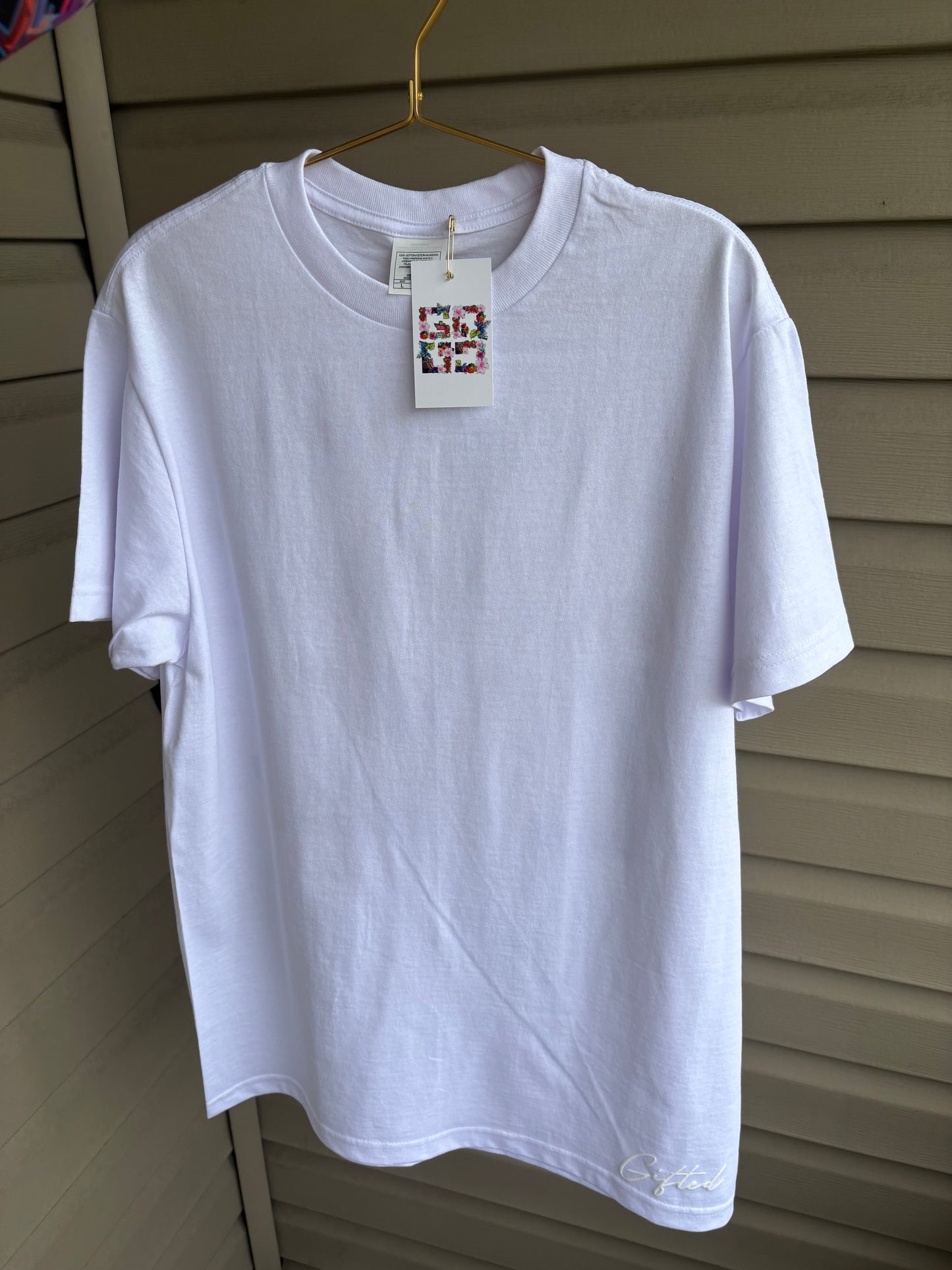 White custom floral t-shirt displayed with hang tag for a stylish casual look