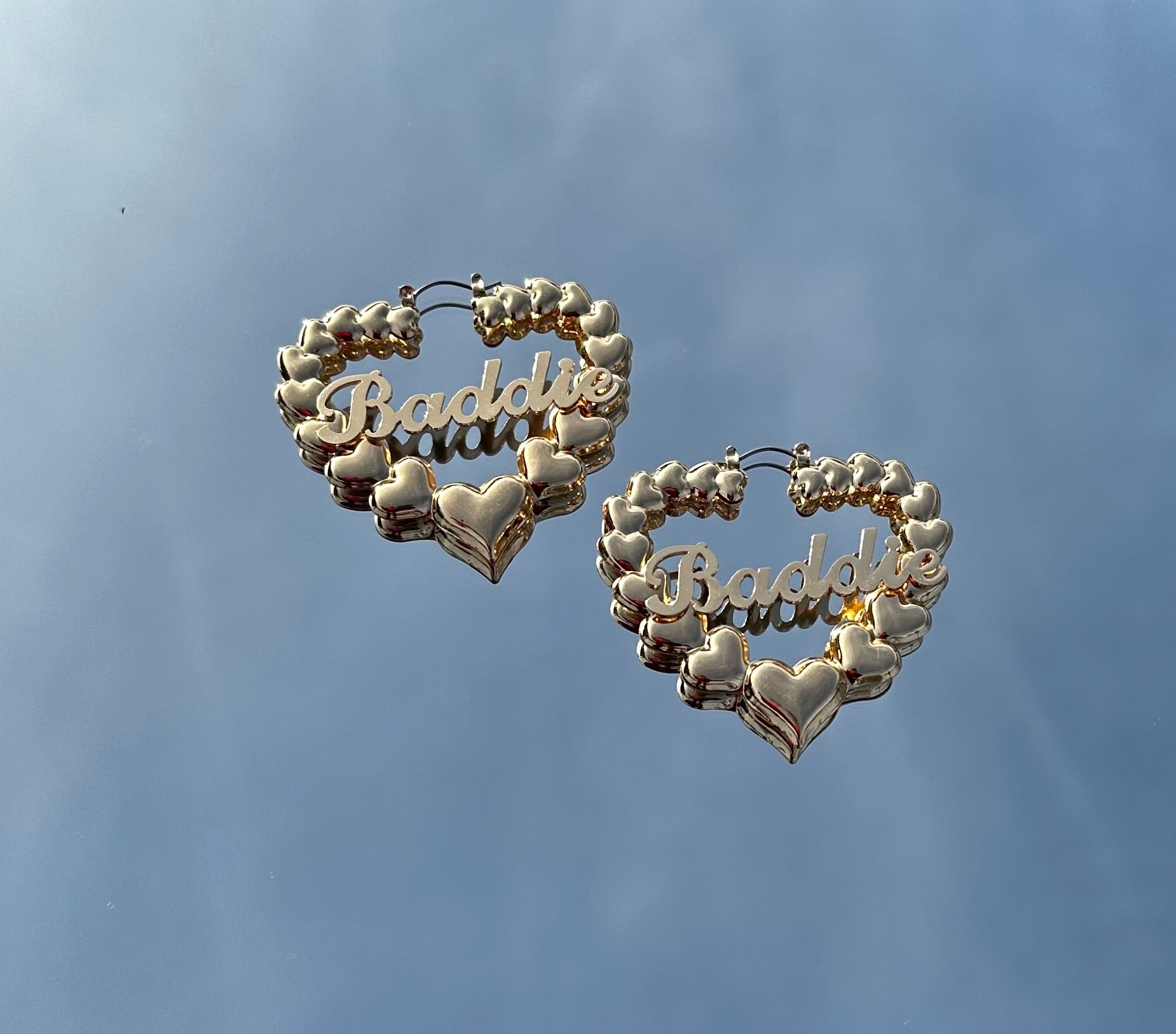 Gold baddie heart earrings featuring a heart-shaped design with the word baddie