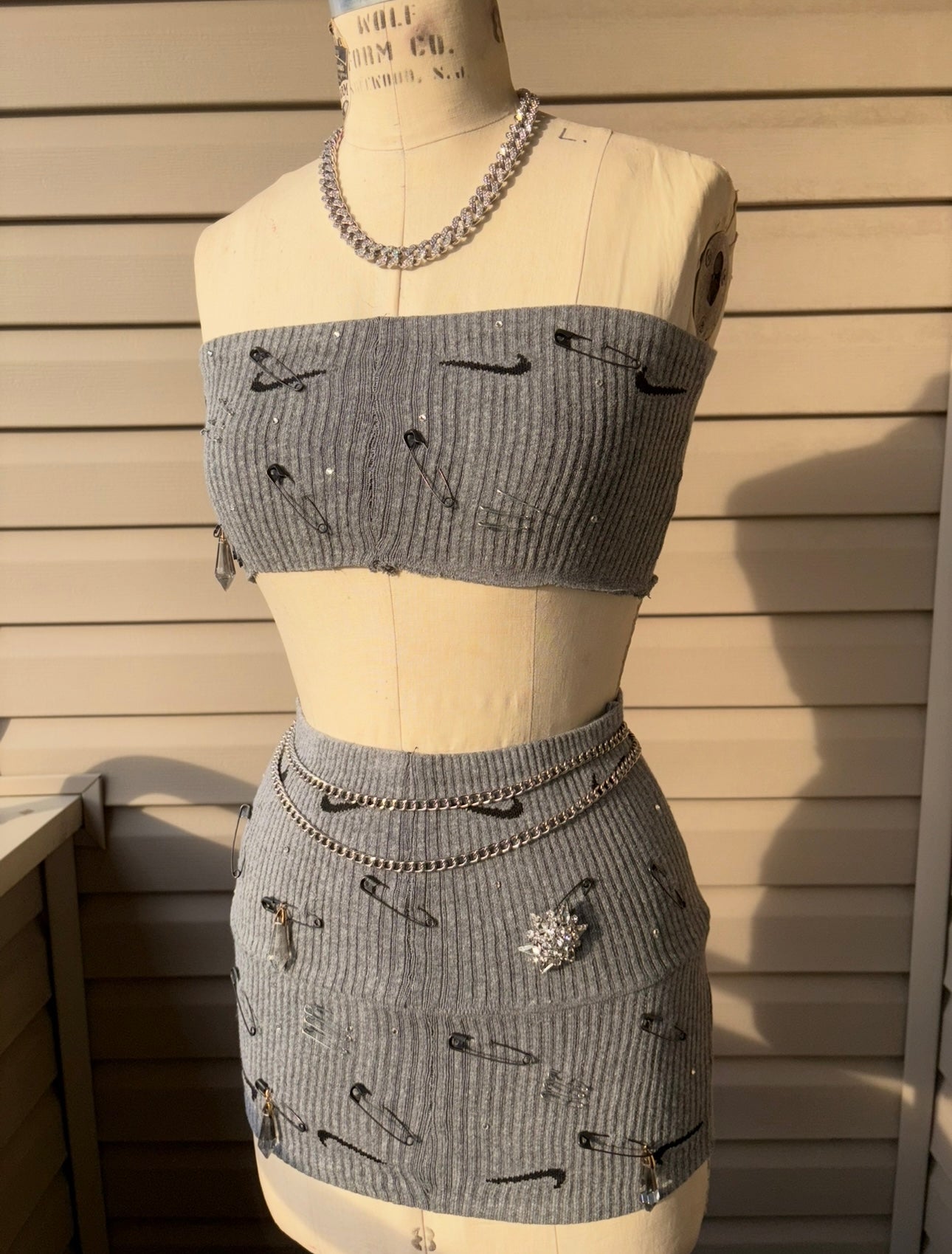 Stylish custom Nike skirt set featuring a fitted top and mini skirt with trendy safety pin details