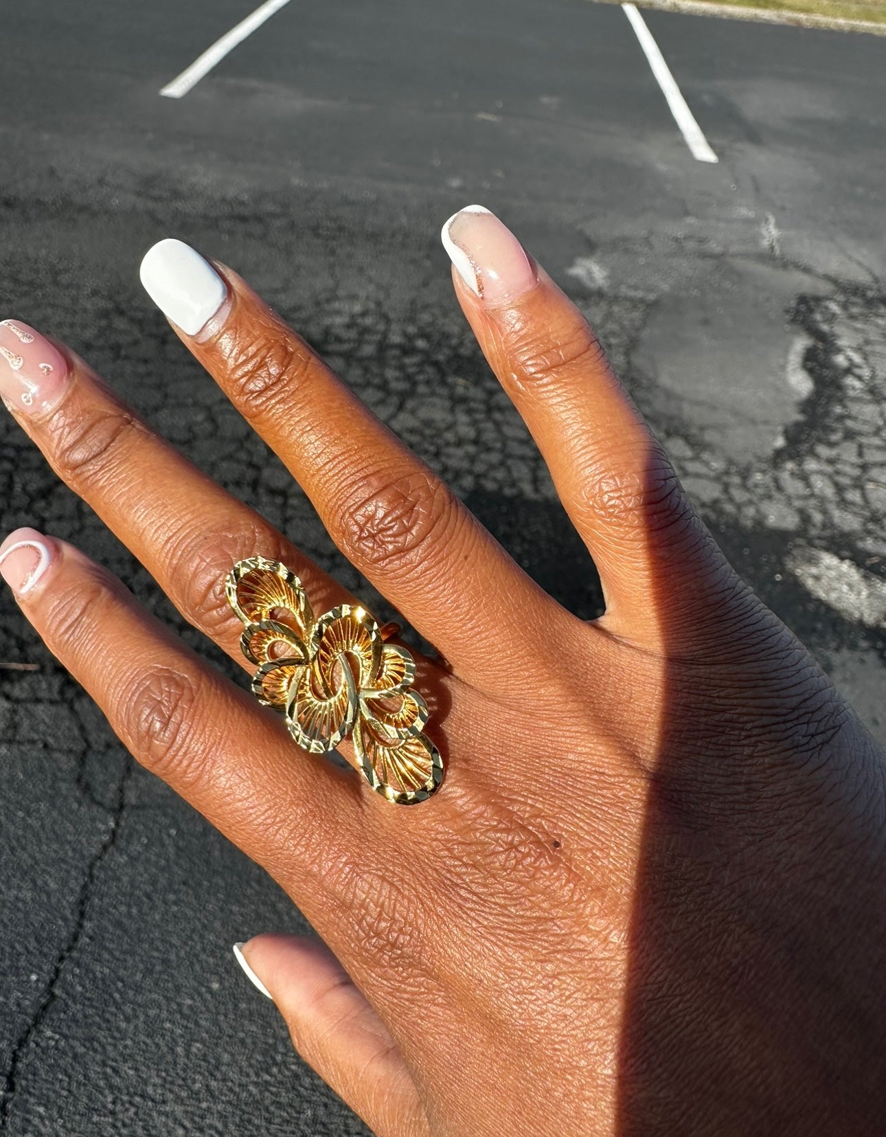 Elegant gold floral ring displayed on a hand with a natural nail polish for a stylish look